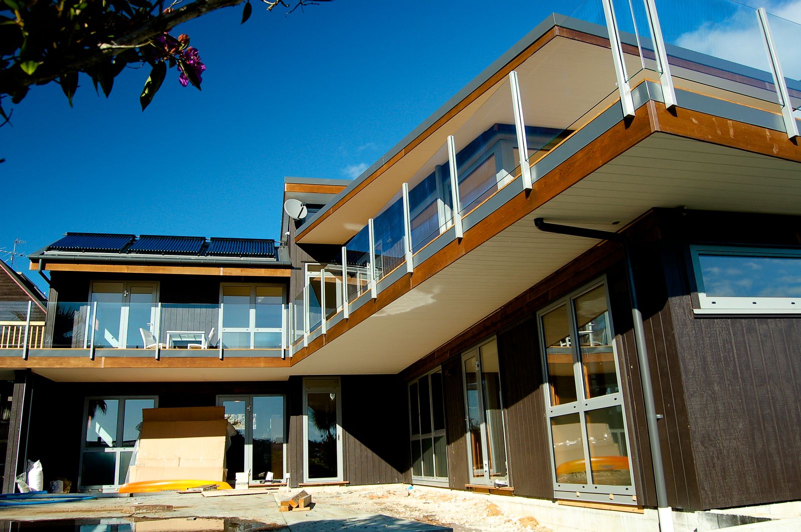 Cantilevered deck with glass balustrade above large glazed doors