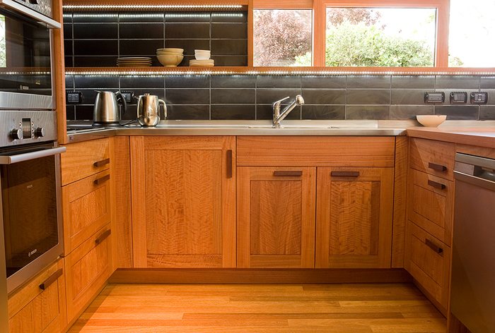 Kitchen with timber cabinetry and a dark tiled splashback